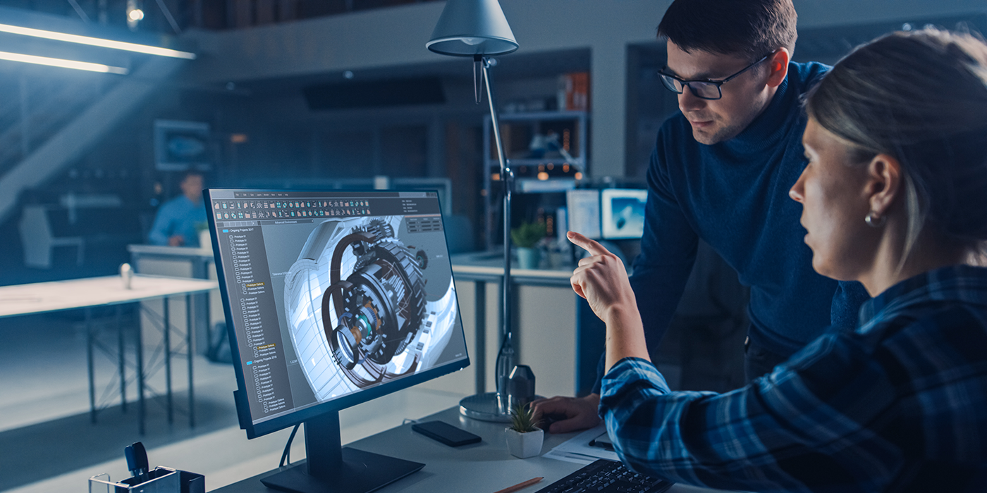 People looking at a computer with a model of complex machinery on the screen