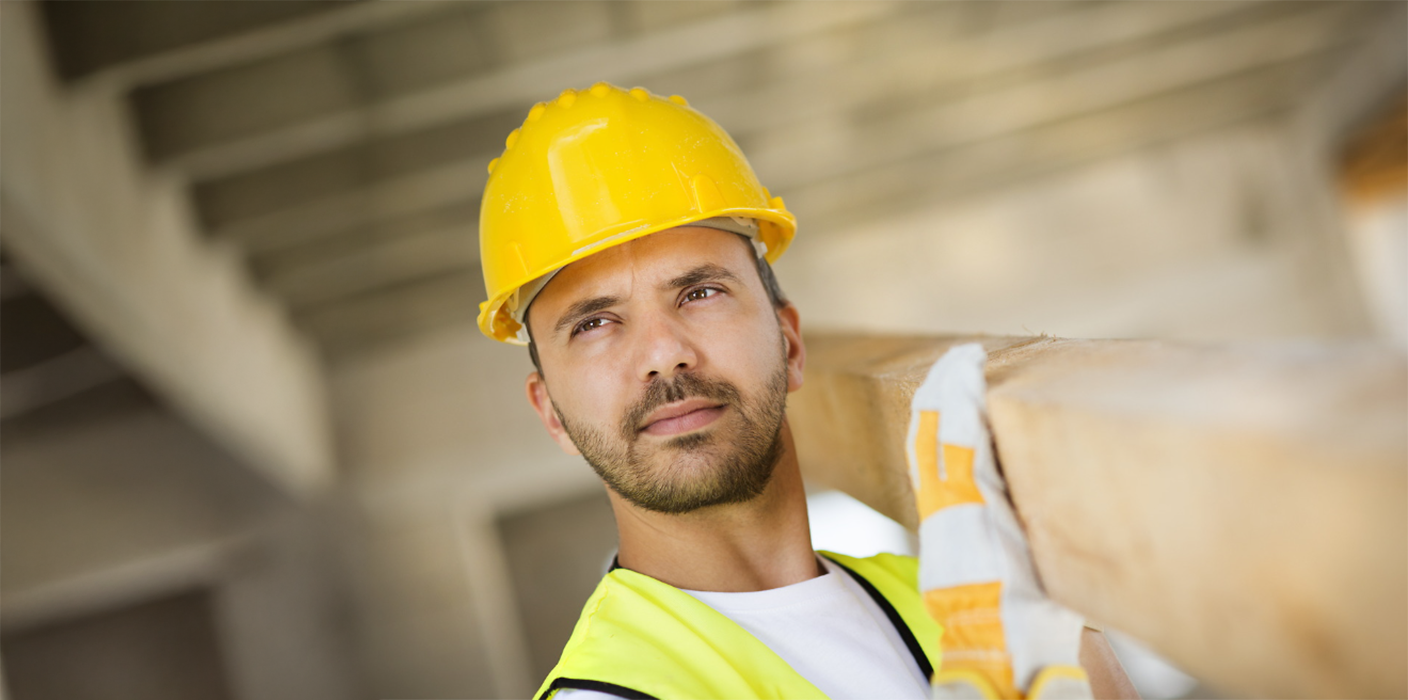 Construction worker holding a board in a building under construction