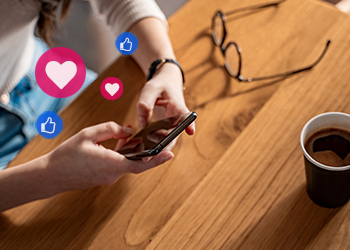 A person using a smart phone with graphics of social media like icons